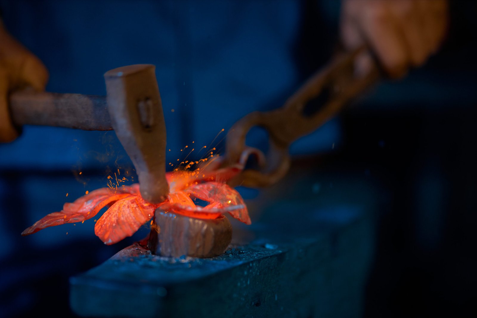 process making decorations for fence in large smithy.